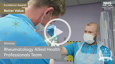 Two male AHP staff, drawing up a vaccine