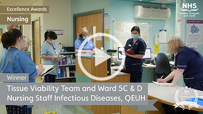 Nursing team, socially distanced, gathered around a nursing station