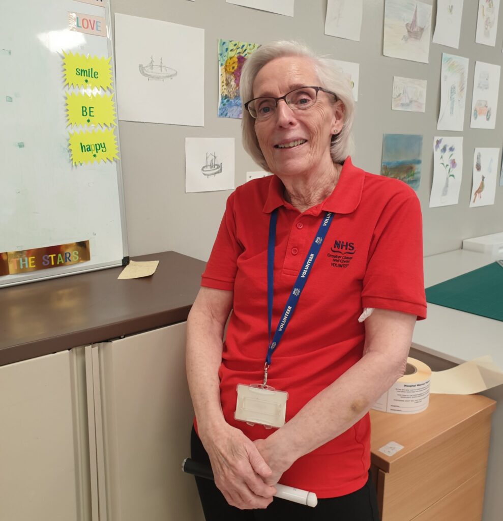 Elizabeth Prior smiles and wears a red volunteer's T-shirt during a shift at Ward 56.