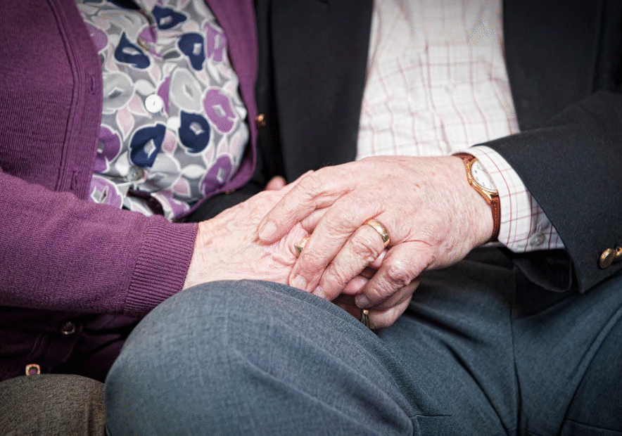 Image of elderly couple holding hands