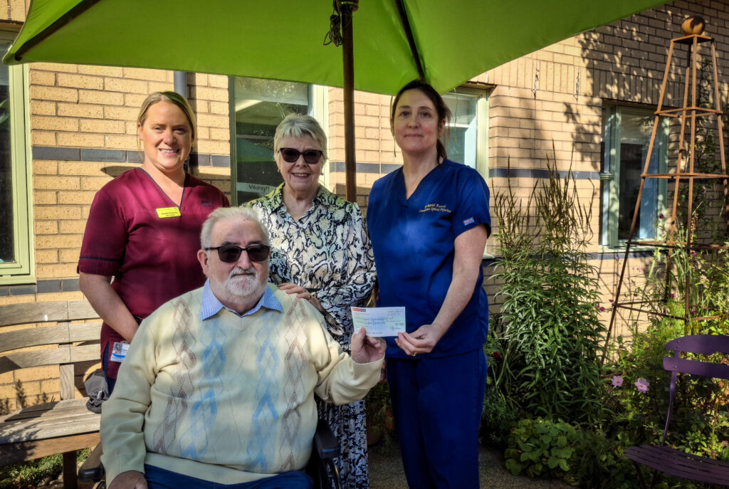 Gordon and Valerie Thallon, centre, present their donation to Lead Clinician Dr Mariel Purcell, right, and Lead Nurse Helena Richmond at the National Spinal Injuries Unit.