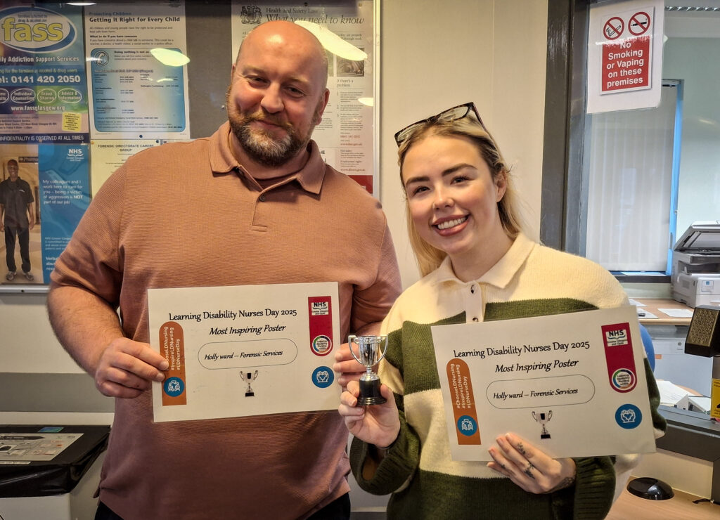 Staff member Fraser Marshall and student nurse Kirsty Henderson holding certificates and a small trophy in recognition of their successful presentation.