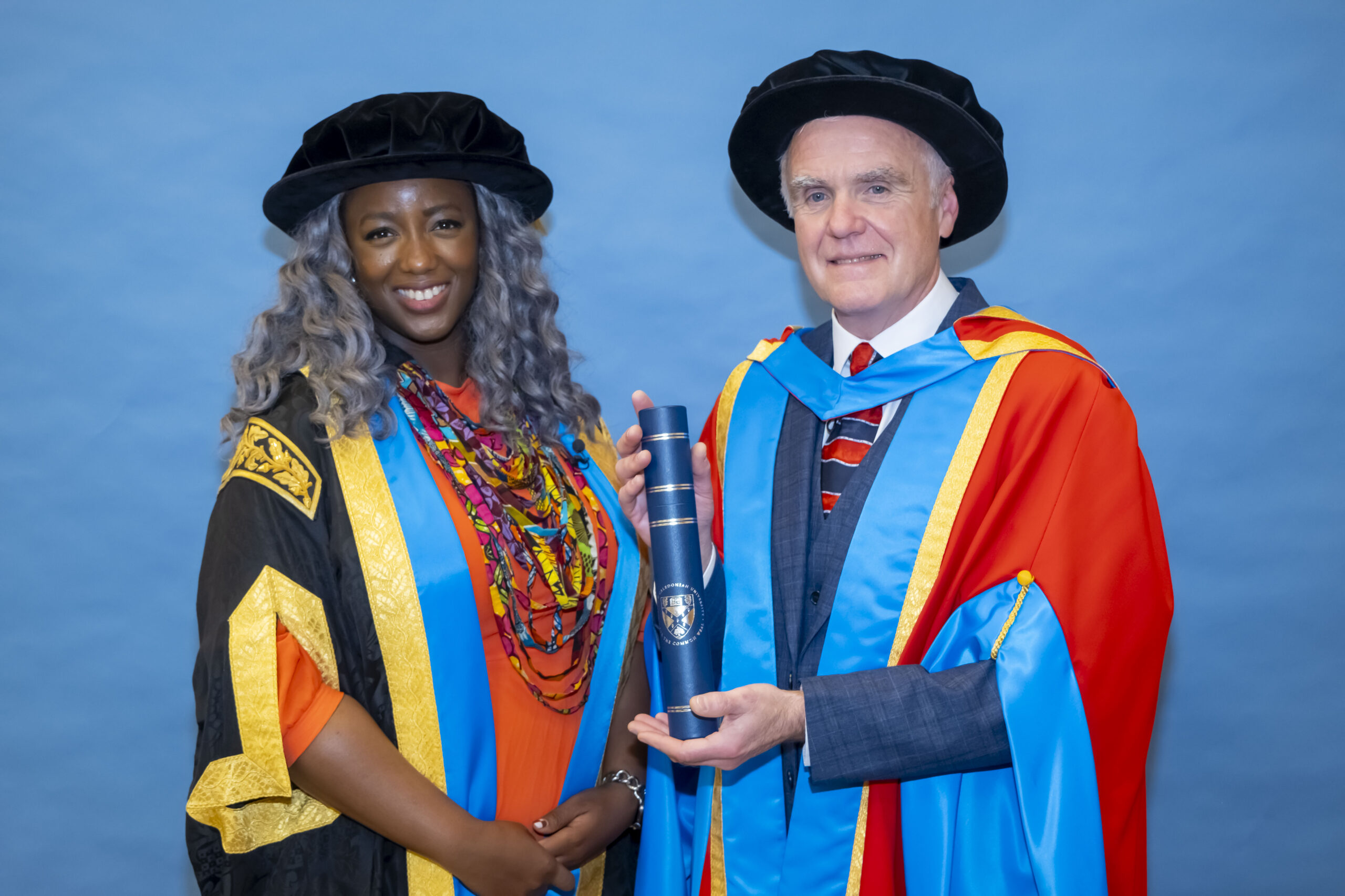 Professor Tom Steele, right, and Dr Anne-Marie Imafidon MBE, Chancellor of Glasgow Caledonian University, stand side by side in their graduation gowns.
