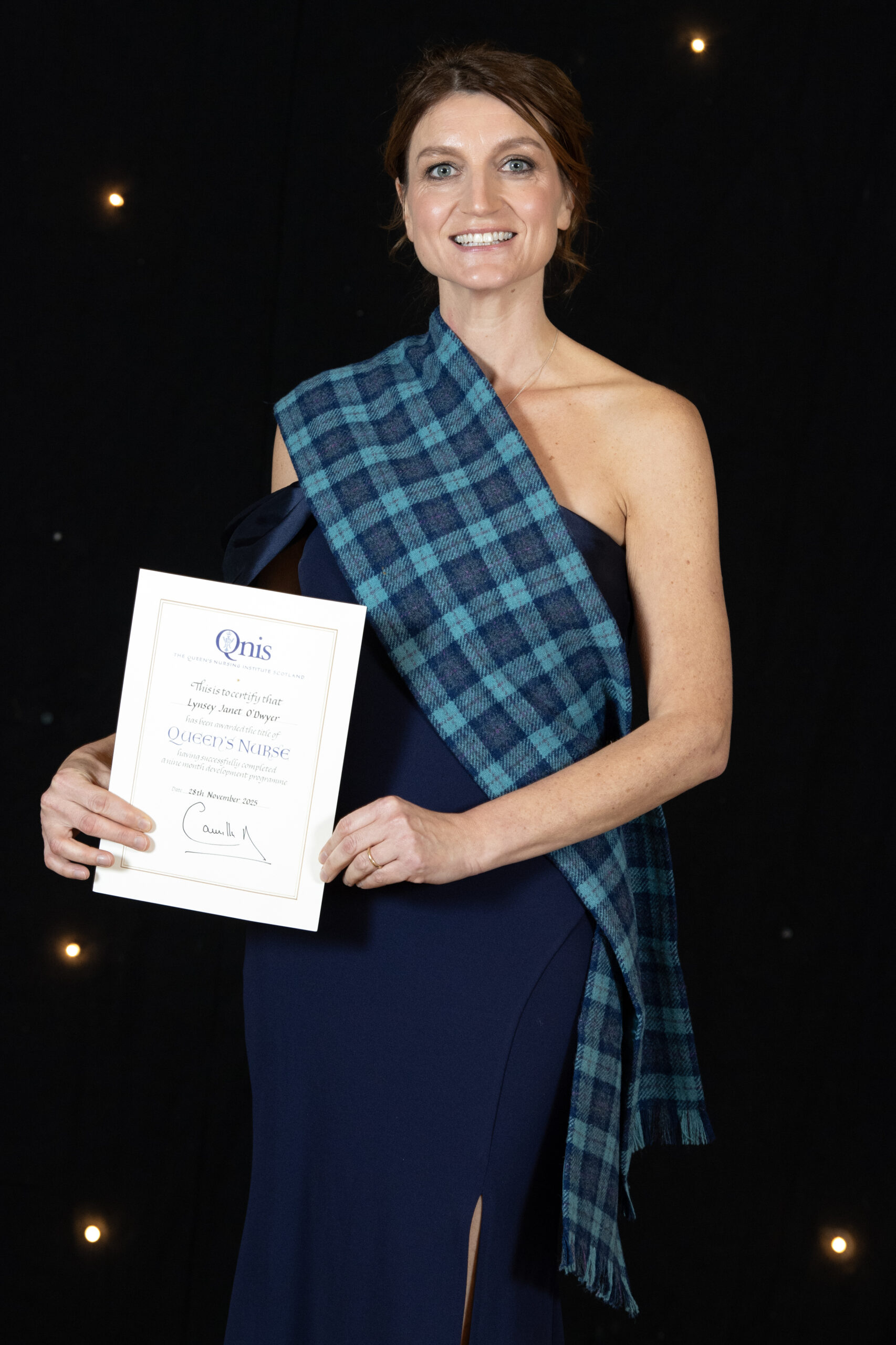 Lynsey O'Dwyer smiling as she holds her Queen's Nurse award.