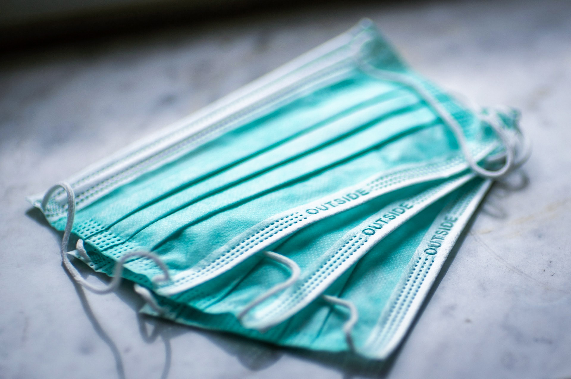 Small pile of three surgical face masks.