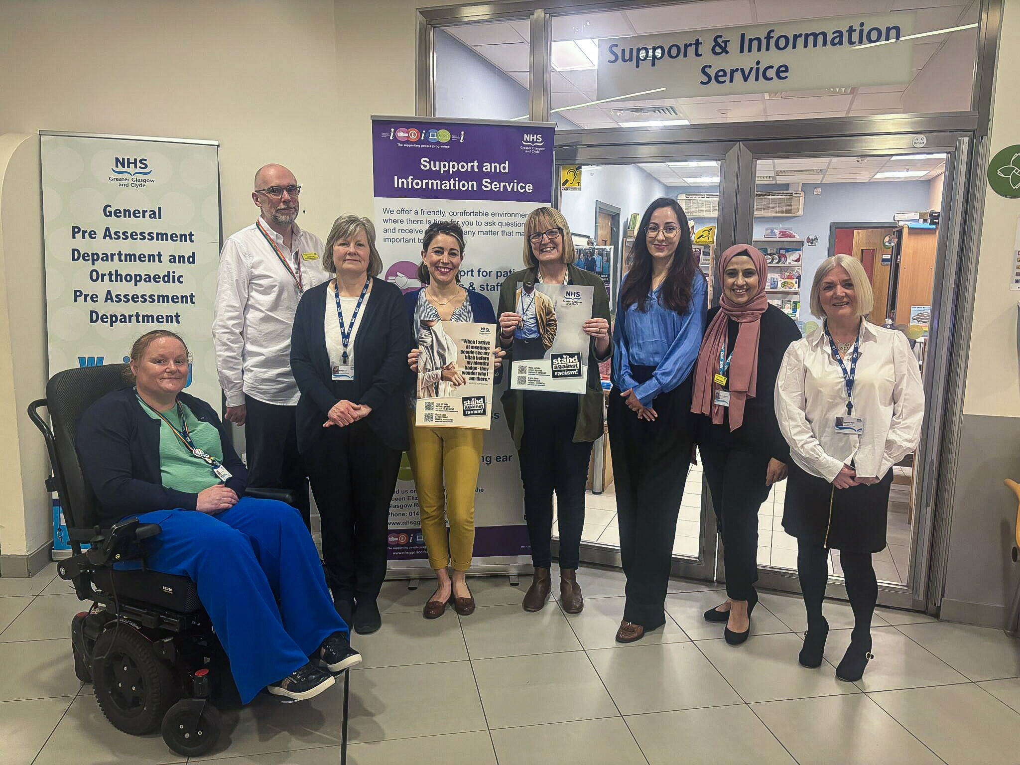 The team from the Support & Information Service line up for a picture outside the service's office in the Queen Elizabeth University Hospital