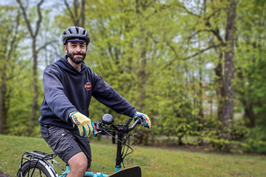 Close-up of Dr Bike Claudio Pia on his cargo bike, with trees in the background