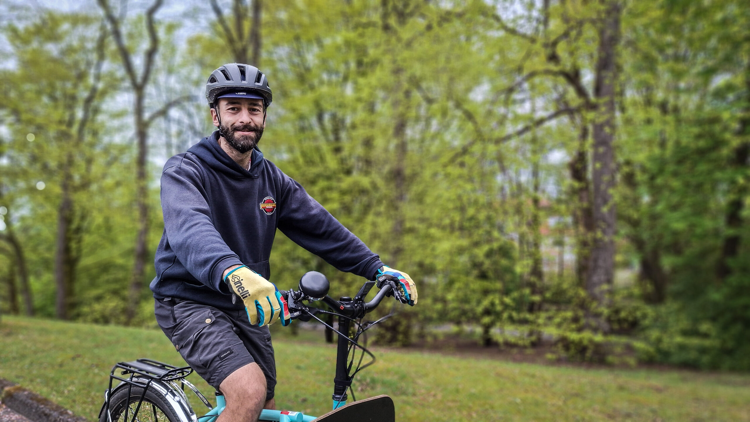 Close-up of Dr Bike Claudio Pia on his cargo bike, with trees in the background
