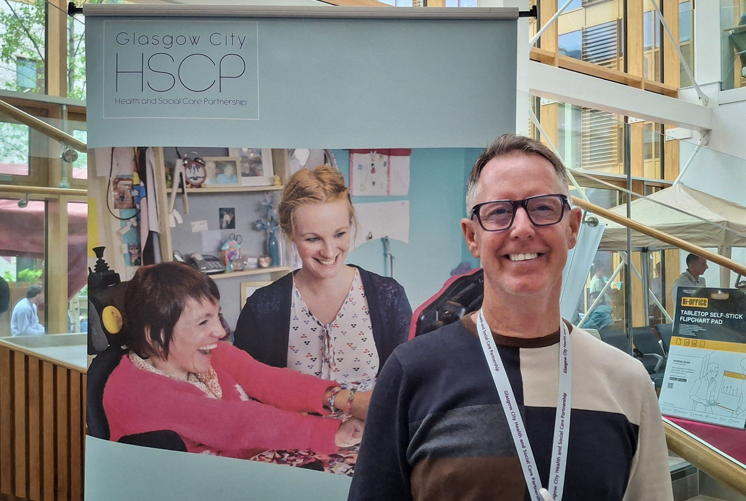 Mark McCourt standing in front of a Glasgow HSCP sign.