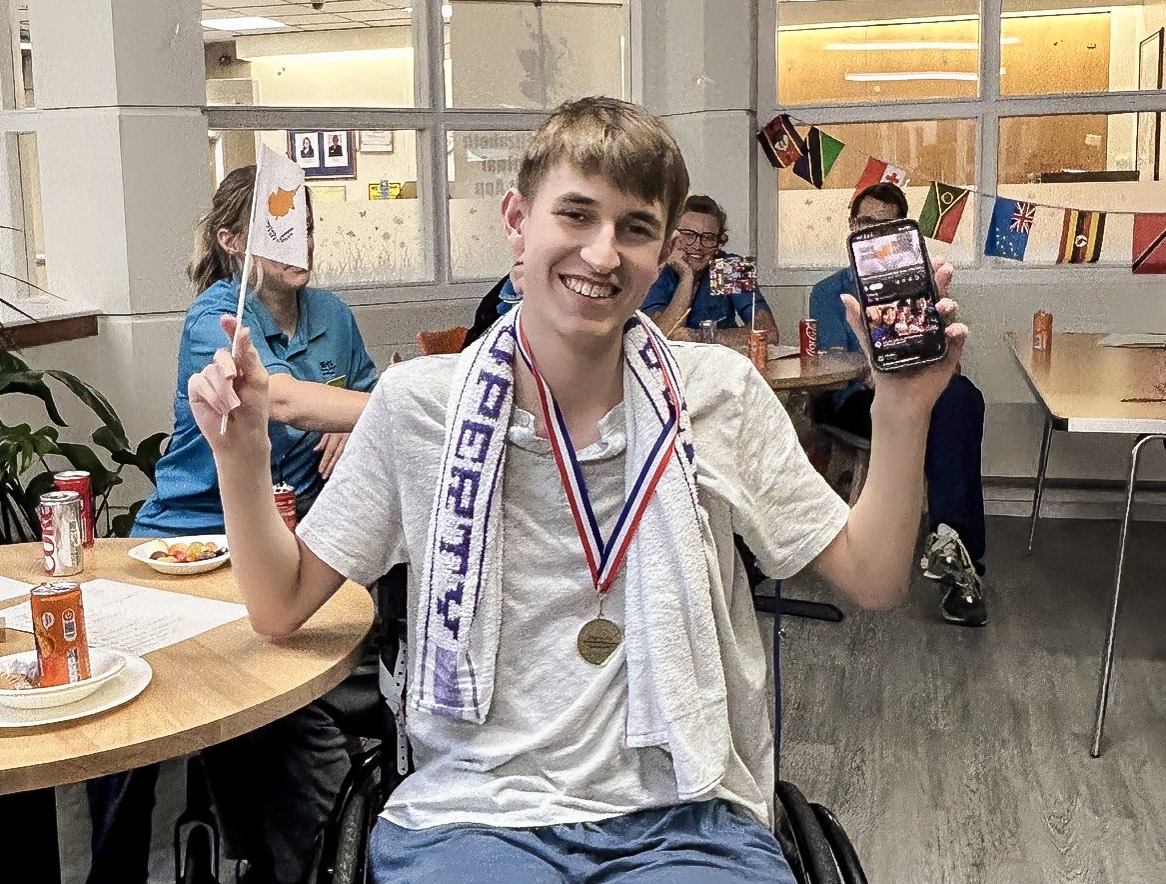 A young patient smiling and wearing his medal after the games