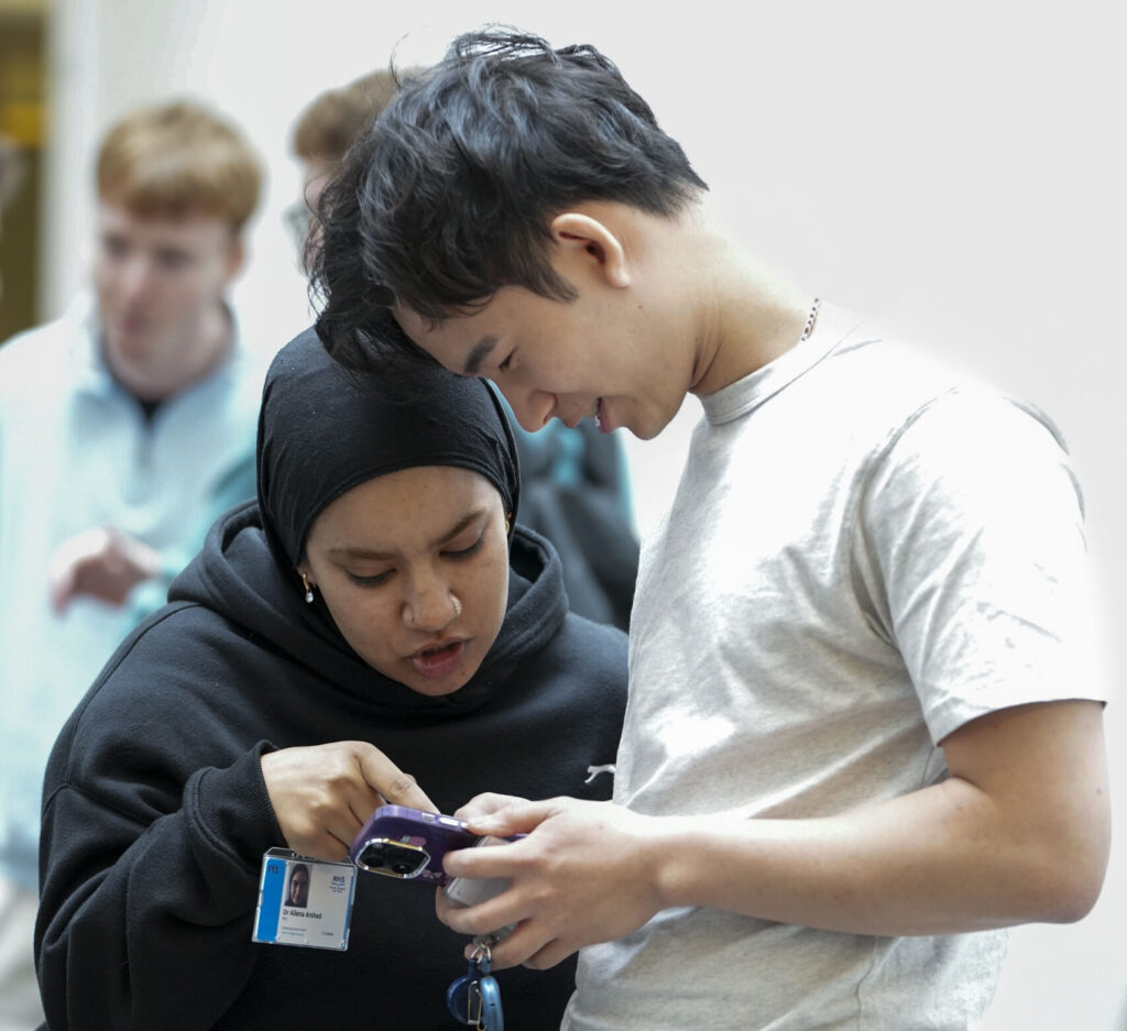 Two FY1s look at a mobile phone while discussing what they're looking at