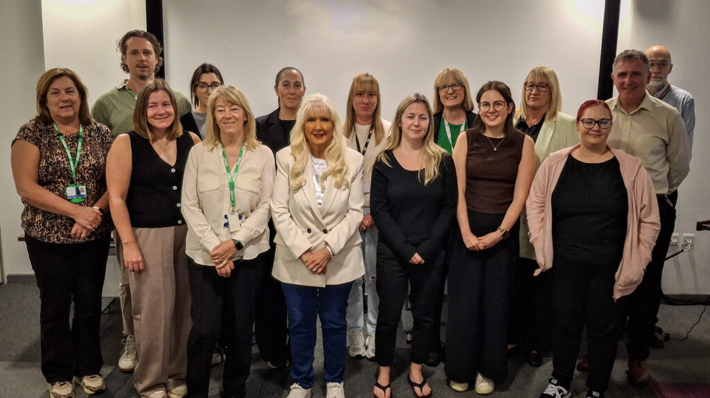 A group of staff and partners standing together for a picture at the partnership event