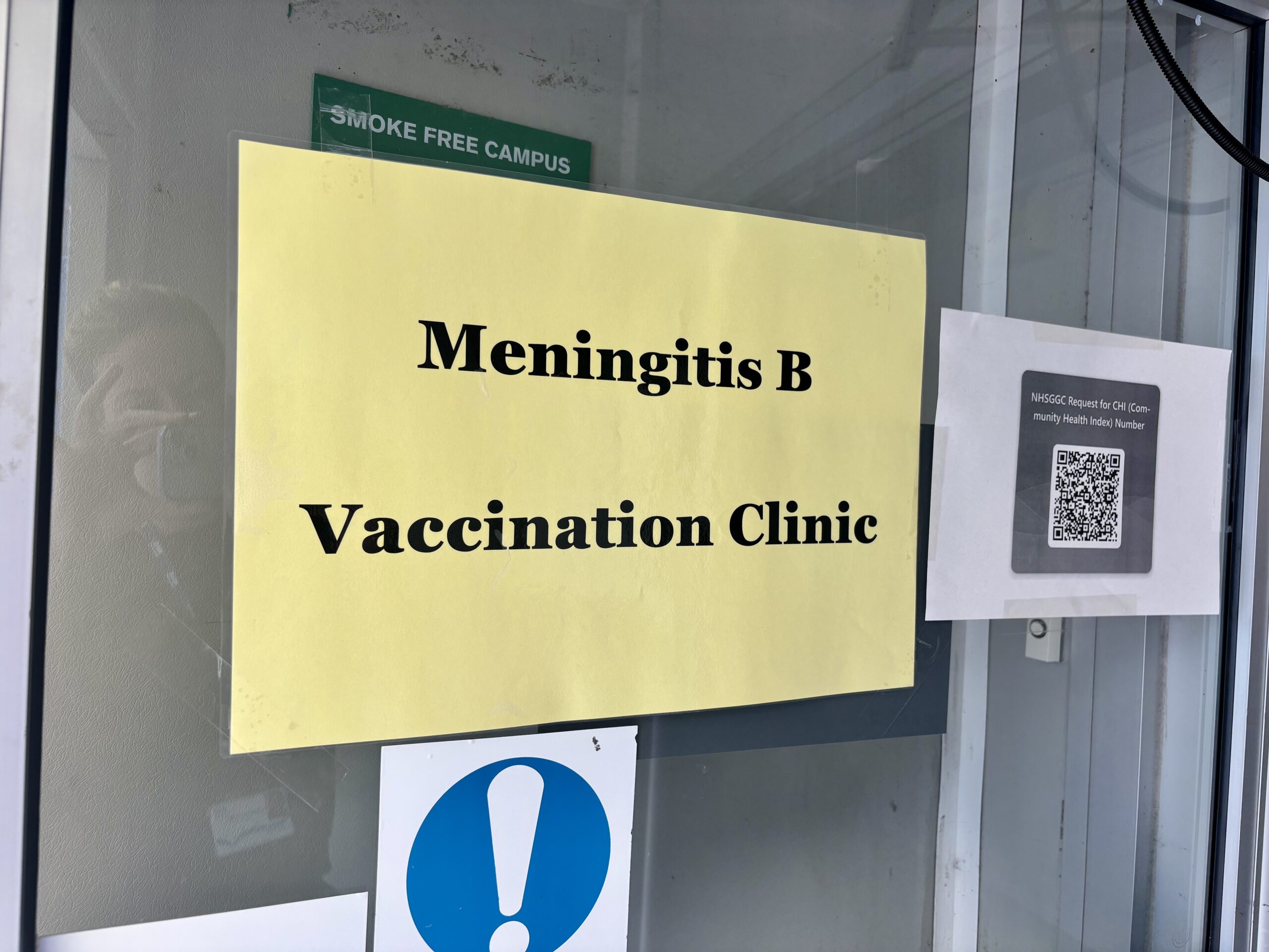 Yellow sign on door saying simply: "Meningitis B Vaccination Clinic"
